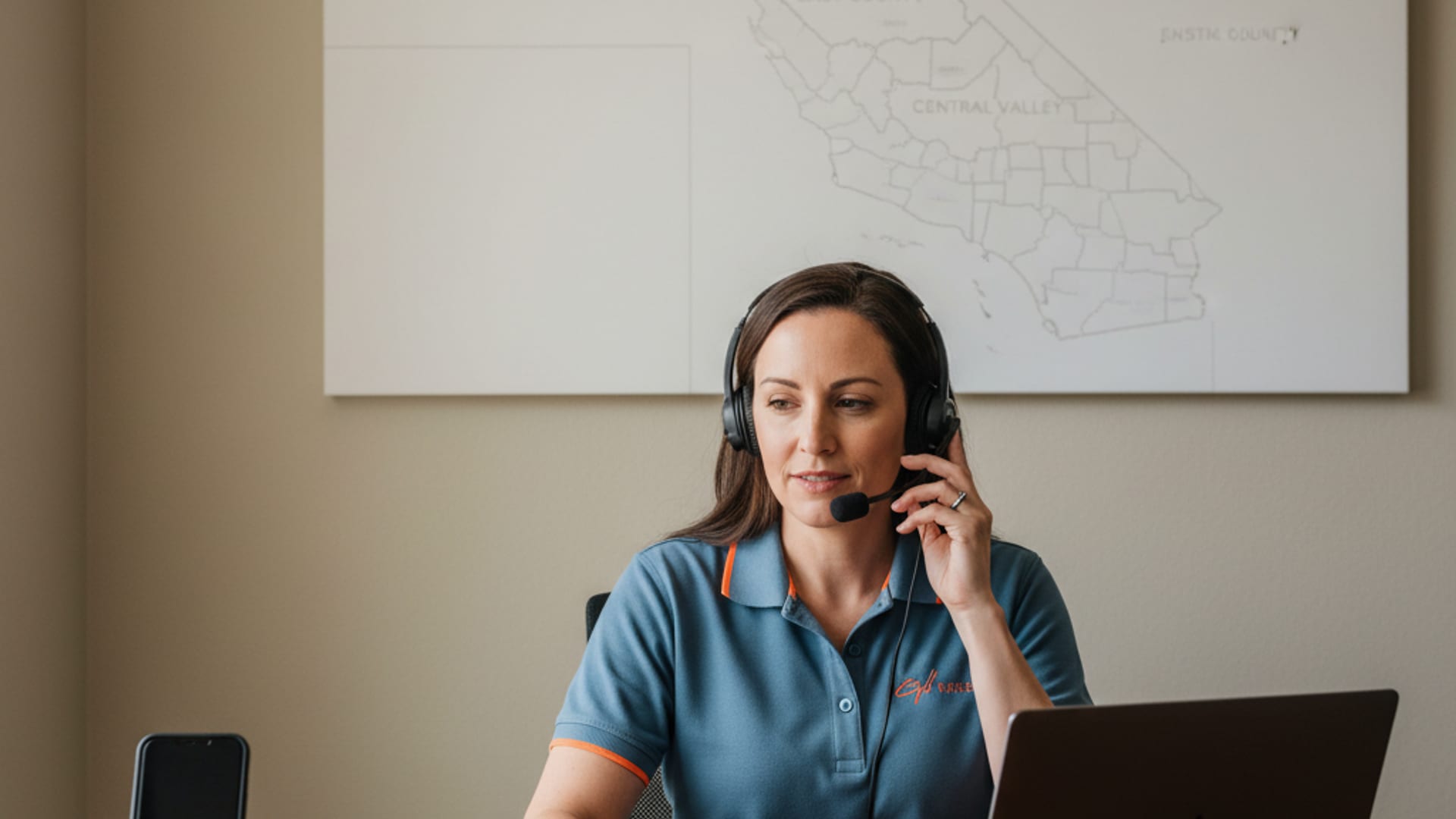 Quick Tow SD dispatcher on the phone with a customer beside a parked flatbed rollback at dusk